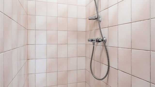 Separat dusjrom i boligens underetasje med vegghengt dusjarmatur.