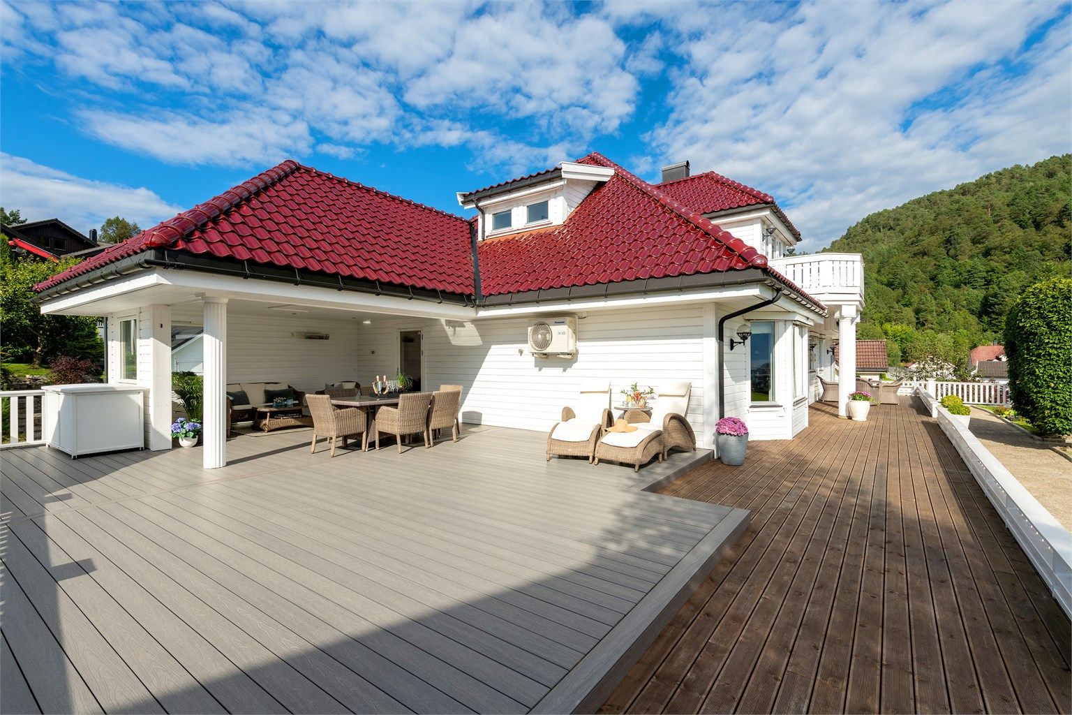 Stor treterrasse på terreng med god plass til flere soner og sitteplasser. 