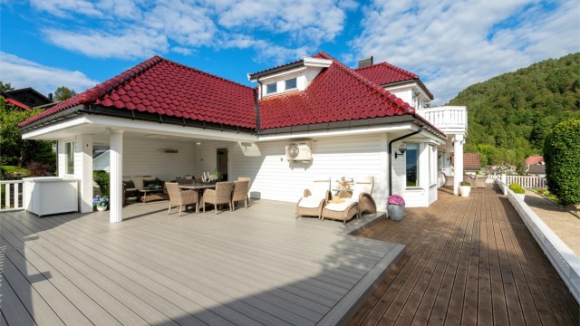 Stor treterrasse på terreng med god plass til flere soner og sitteplasser.