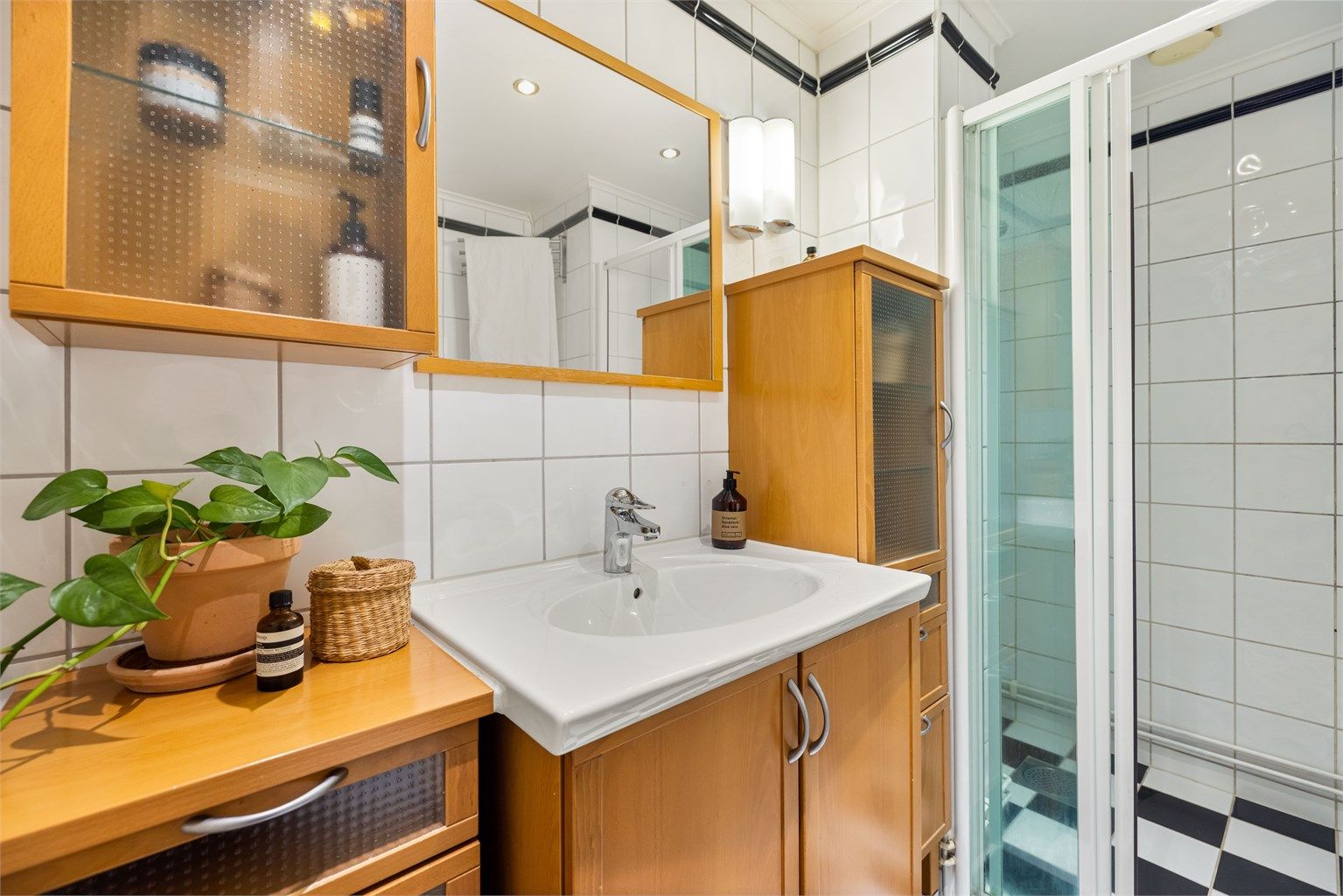 Badet er innredet med servantskap, ovenpåliggende servant, speil og dusjsone med skyvedør i glass. Baderommet er fra 2000 og renovert i regi av aksjelaget.