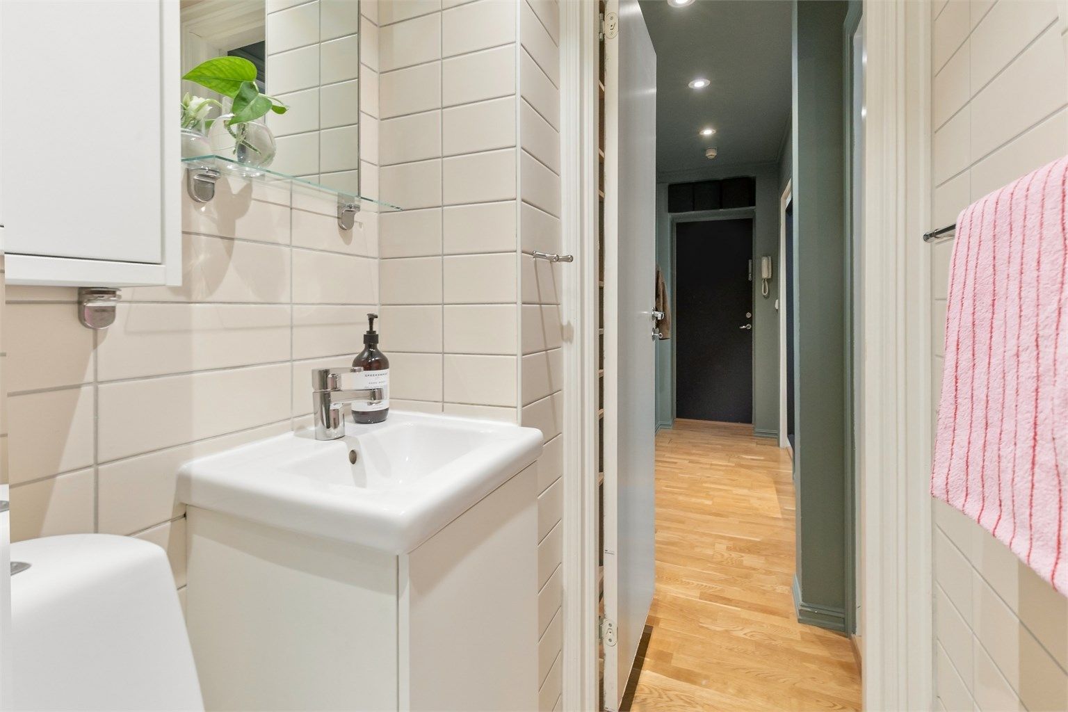 Badet har vegghengt servantinnredning og speilskap.