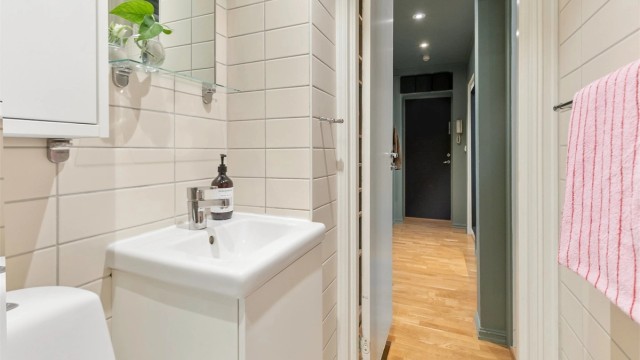Badet har vegghengt servantinnredning og speilskap.