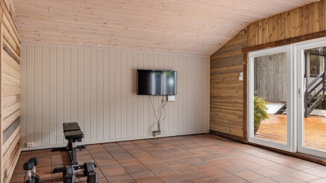 Frittstående utestue på 21 kvm med utgang til en flislagt terrasse.