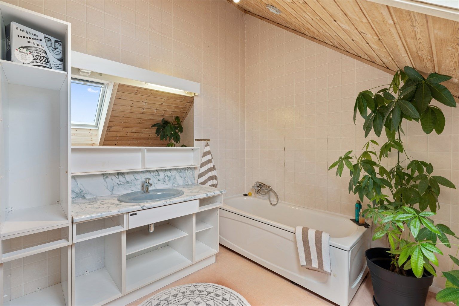 Badet er innredet med badekar og servantinnredning med god lagringsplass.