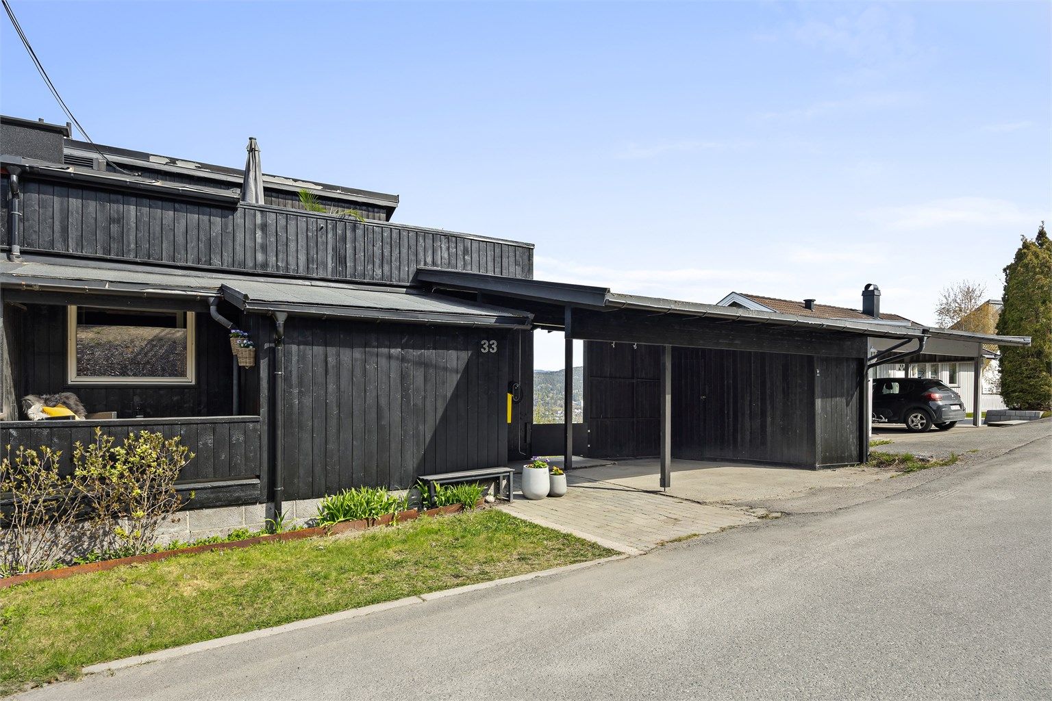 Carport med lader til el-bil og overbygget inngangsparti.