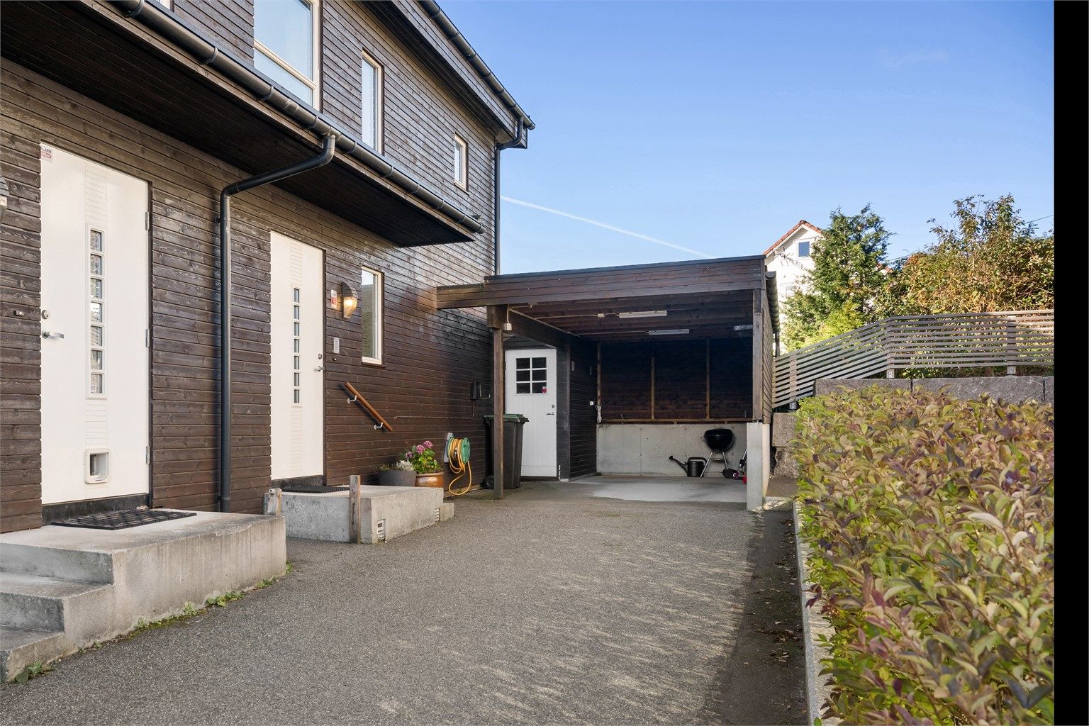 Boligen har egen carport med elbillader, praktisk plassert ved inngangspartiet