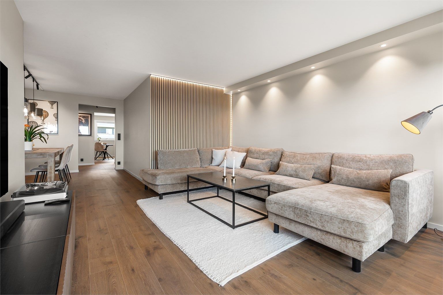 I stuen er det plass til sittegruppe og TV-område. Den åpne løsningen mot spisestuen skaper en sosial atmosfære når man er med venner og familie.