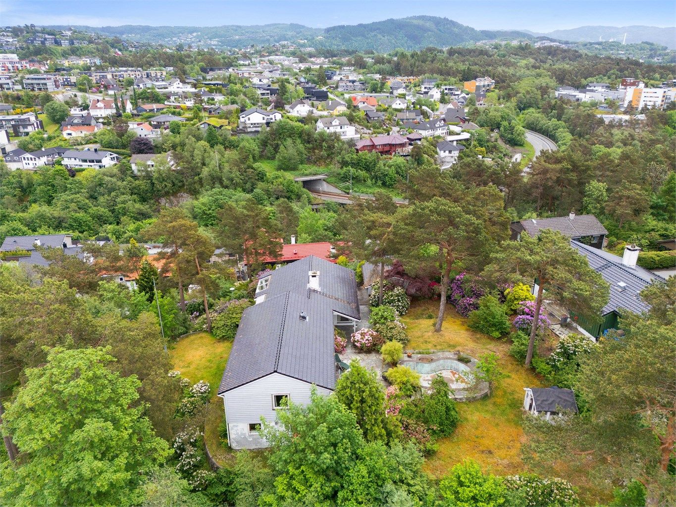 En fantastisk beliggende tomt på et lite høydedrag i rolige, naturvennlige omgivelser med en parklignende hage rundt hele huset.