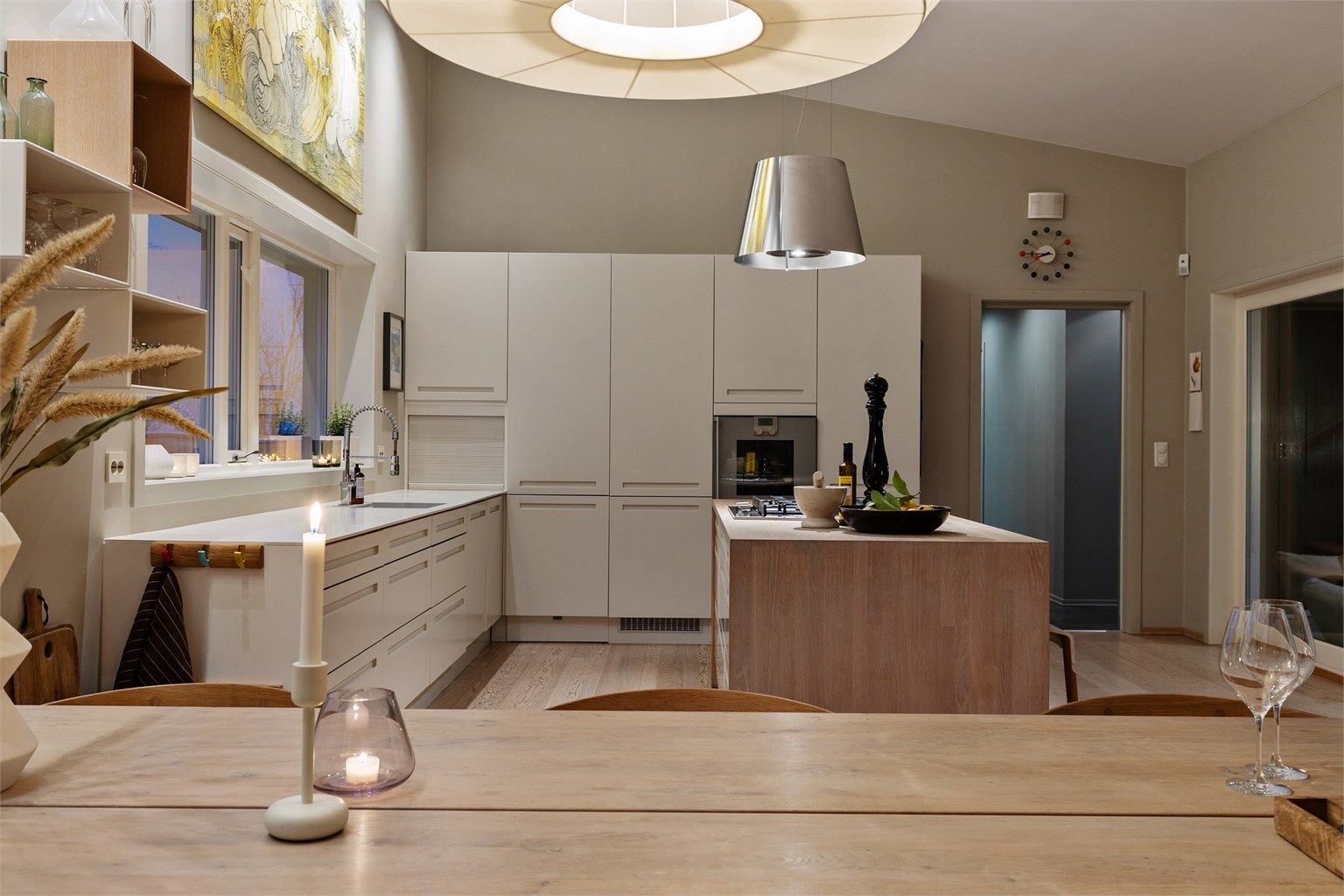 Åpen kjøkkenløsning mot stue. Kjøkkeninnredning med slette fronter. Benkeplate av tre og laminat. Nedfelt oppvaskkum med ett-greps armatur. Stikkontakter på vegg over kjøkkenbenk.