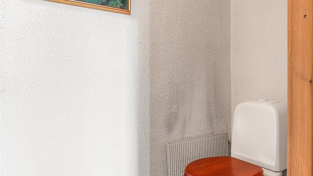 Separat toalettrom i boligens underetasje med gulvstående toalett og vegghengt servant.