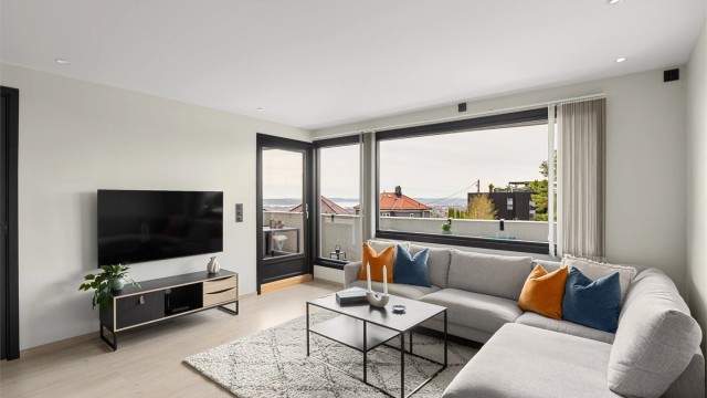 Stuen er romslig og har store vindusflater som gir godt med naturlig lys, samtidig som man kan nyte utsikten fra hele rommet