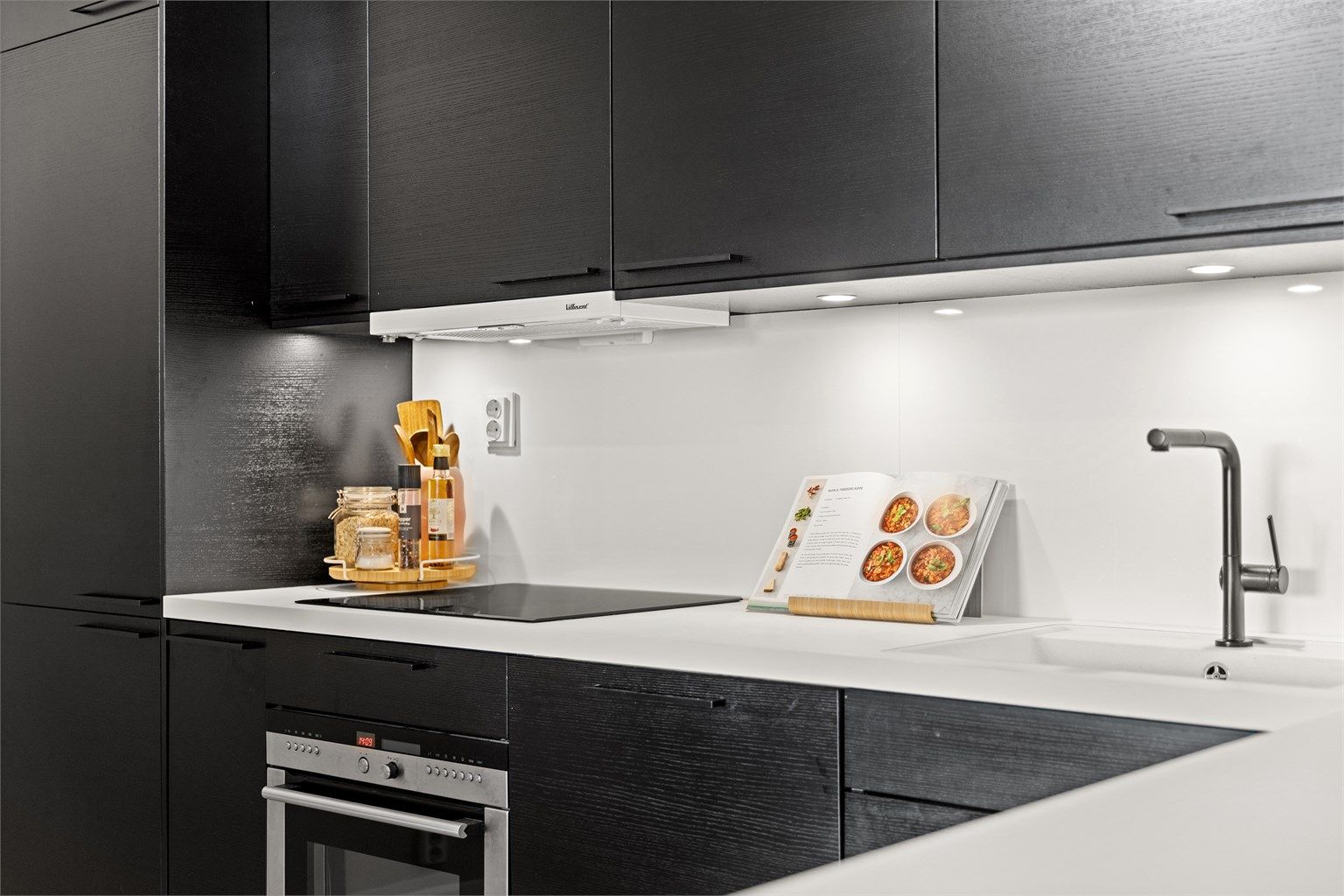 Kjøkkenet består av glatte fronter og benkeplate av laminat.