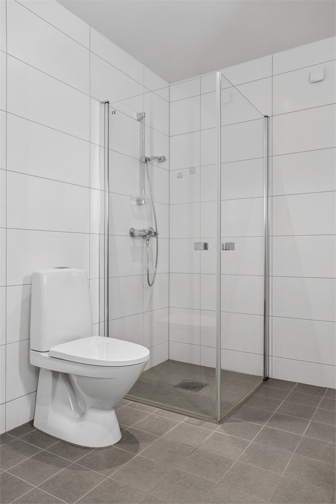 Rommet er utstyrt med vegghengt servantinnredning, dusjhjørne og toalett.