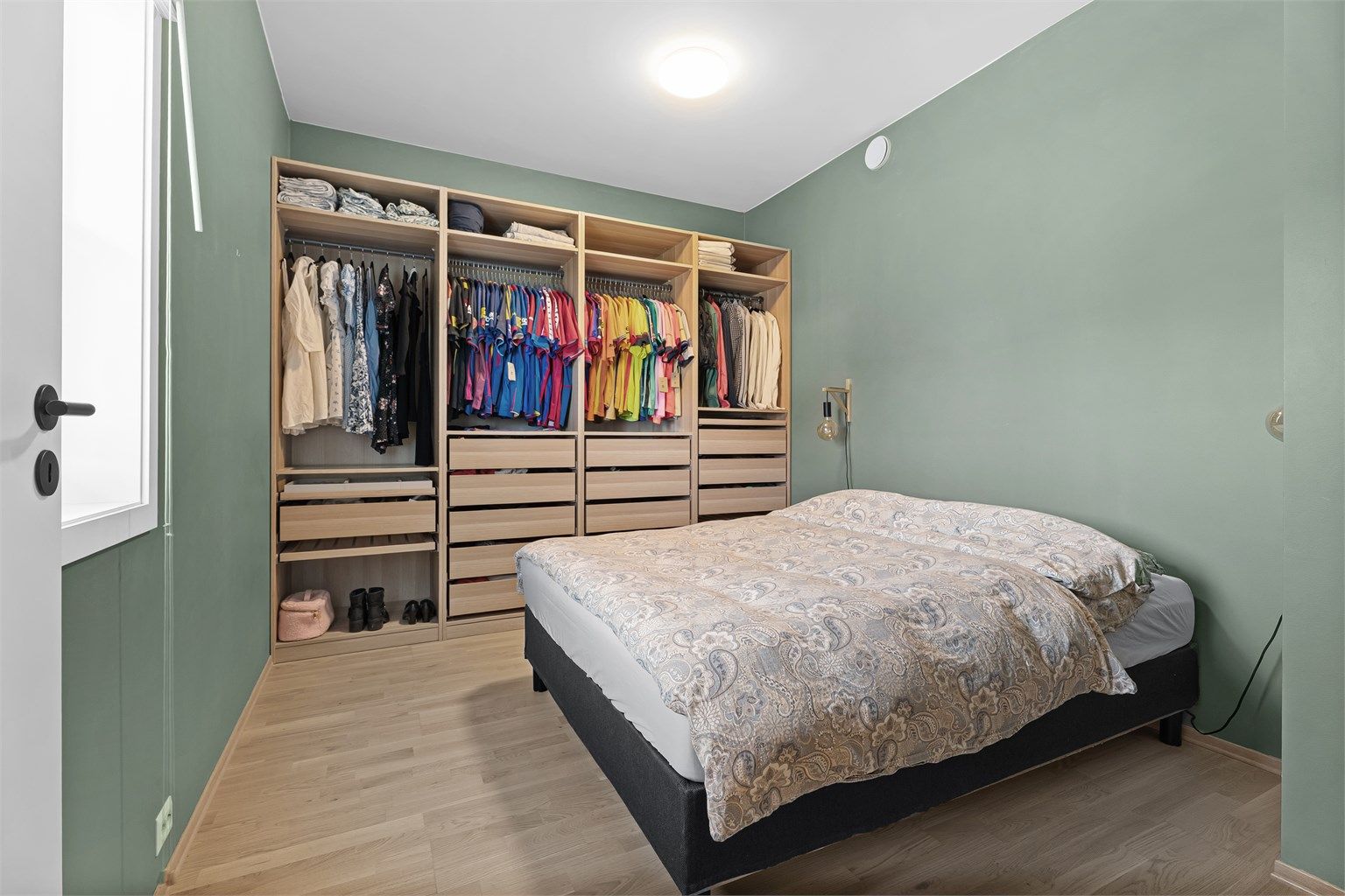 Stort og innbydende soverom med garderobeskap langs hele veggen. Her er det en god kombinasjon av skuffer, oppheng og hyller. I tillegg er det ekstra lagring på toppen om ønskelig.