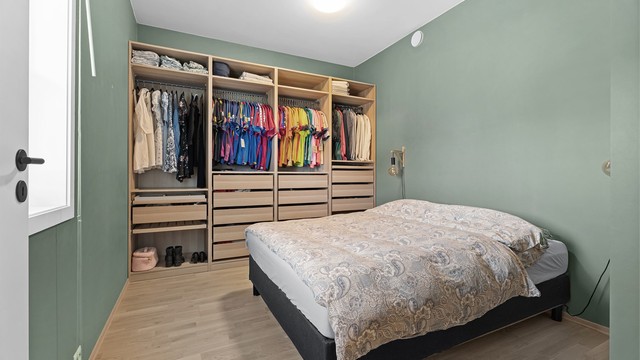 Stort og innbydende soverom med garderobeskap langs hele veggen. Her er det en god kombinasjon av skuffer, oppheng og hyller. I tillegg er det ekstra lagring på toppen om ønskelig.