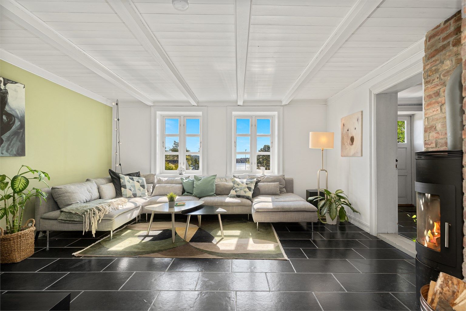 Koselig stue med flott utsikt og peisovn.