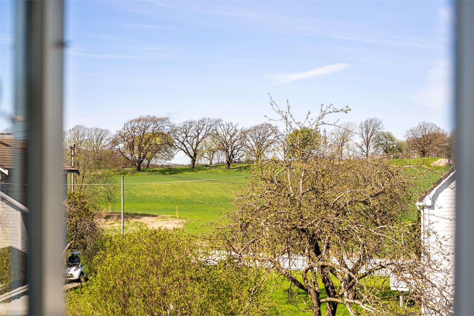 Mot vest sees fin utsikt til vakkert åkerlandskap og skogholtene rundt Hafslund hovedgård.