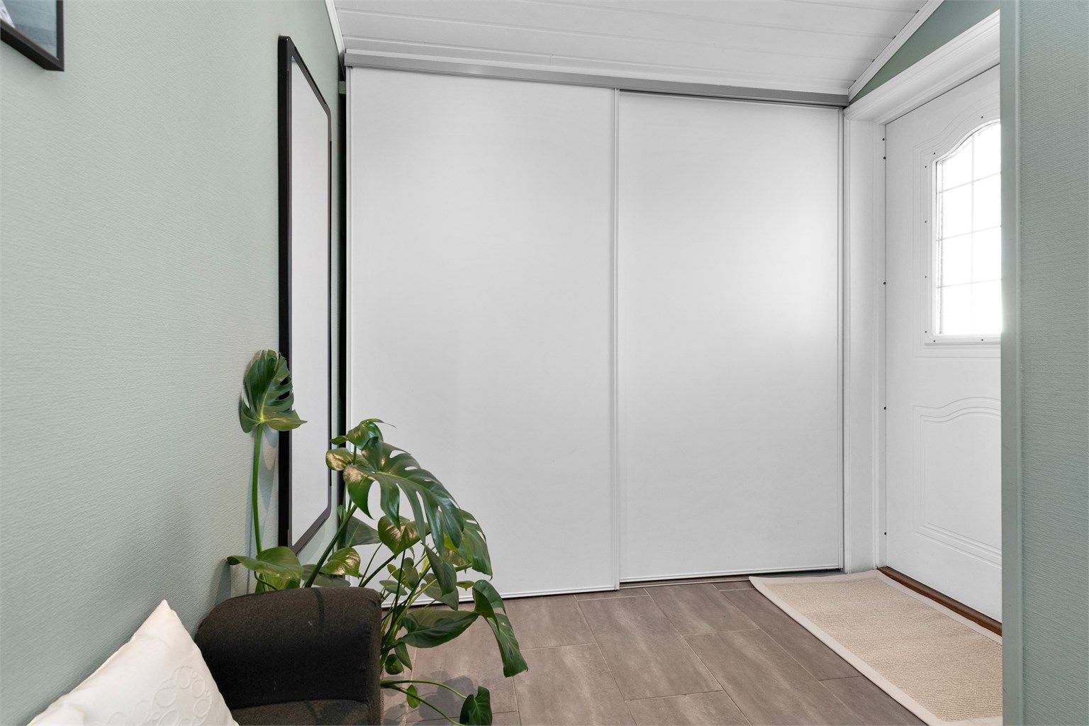 En stor skyvedørsgarderobe i vindfanget gir rikelig med plass til yttertøy og sko