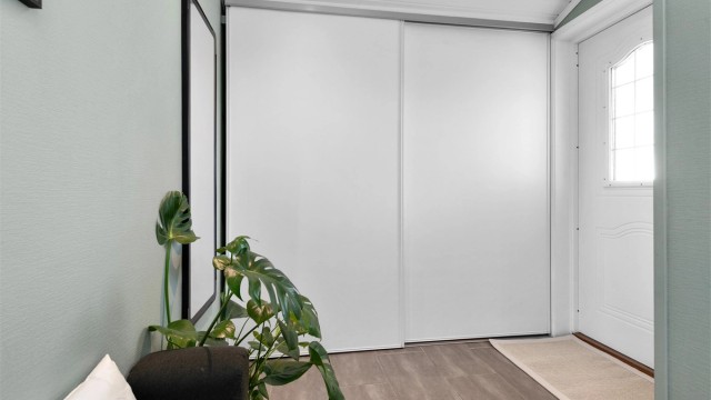 En stor skyvedørsgarderobe i vindfanget gir rikelig med plass til yttertøy og sko