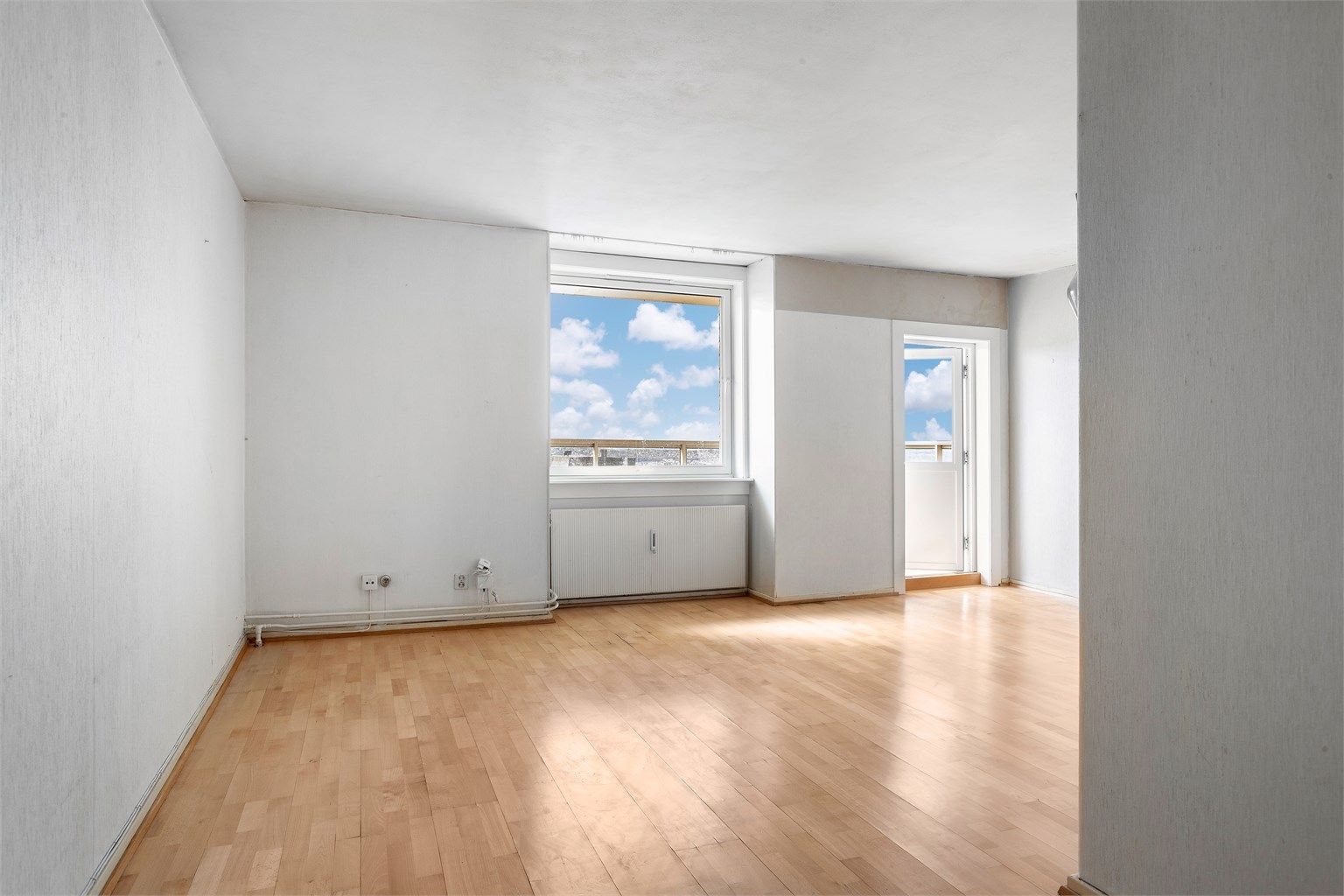 Stuen har parkett på gulv og plass til både sofagruppe og spisebord.