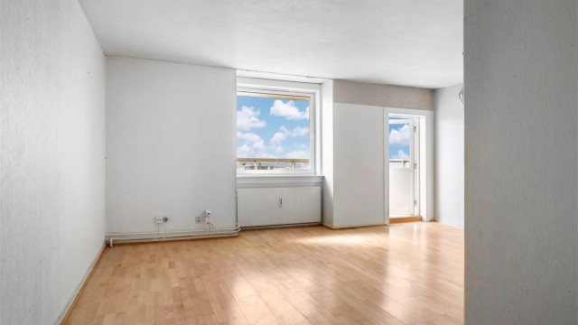 Stuen har parkett på gulv og plass til både sofagruppe og spisebord.