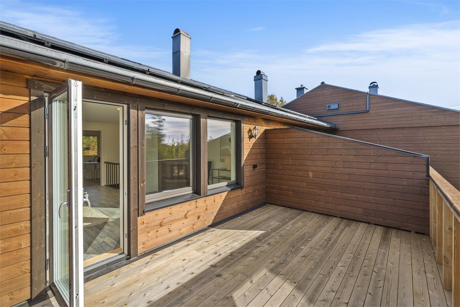 Fra stuen er det direkte utgang til en ny, vestvendt balkong med levegger og grønne omgivelser.
Foto: [Fotograf Magik
]