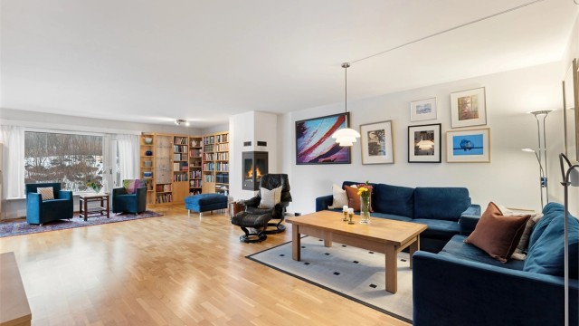 Oversiktsbilde som viser stuen i sin helhet, med peis og utgang til terrasse.