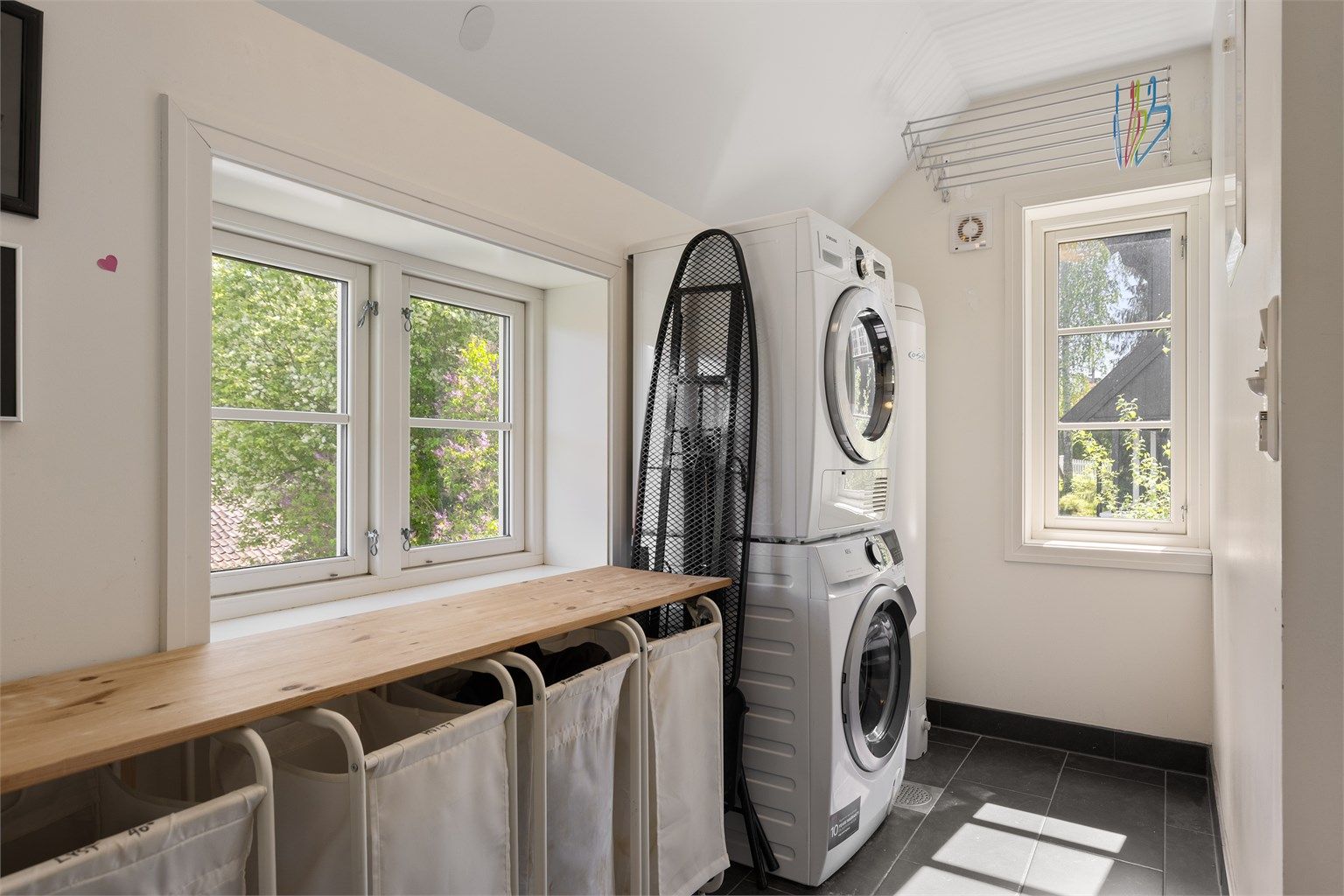 Videre fra badet er det tilgang til et separat vaskerom. Rommet er innredet med opplegg til vaskemaskin og plass til en tørketrommel på toppen av vaskemaskinen, varmtvannsbereder. Det er også god plass til en brettebenk med skittentøyskurver under.