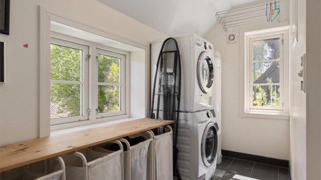 Videre fra badet er det tilgang til et separat vaskerom. Rommet er innredet med opplegg til vaskemaskin og plass til en tørketrommel på toppen av vaskemaskinen, varmtvannsbereder. Det er også god plass til en brettebenk med skittentøyskurver under.