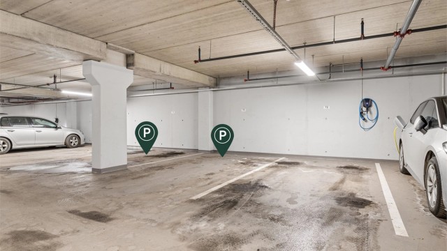 Leiligheten har 2 garasjeplasser i et stort garasjeanlegg (U2) med god plass til manøvrering. Det er direkte adkomst fra garasjeanlegget via heis og opp til leilighetens etasjeplan. Systemet leser bilskiltet og åpner garasjeportene automatisk