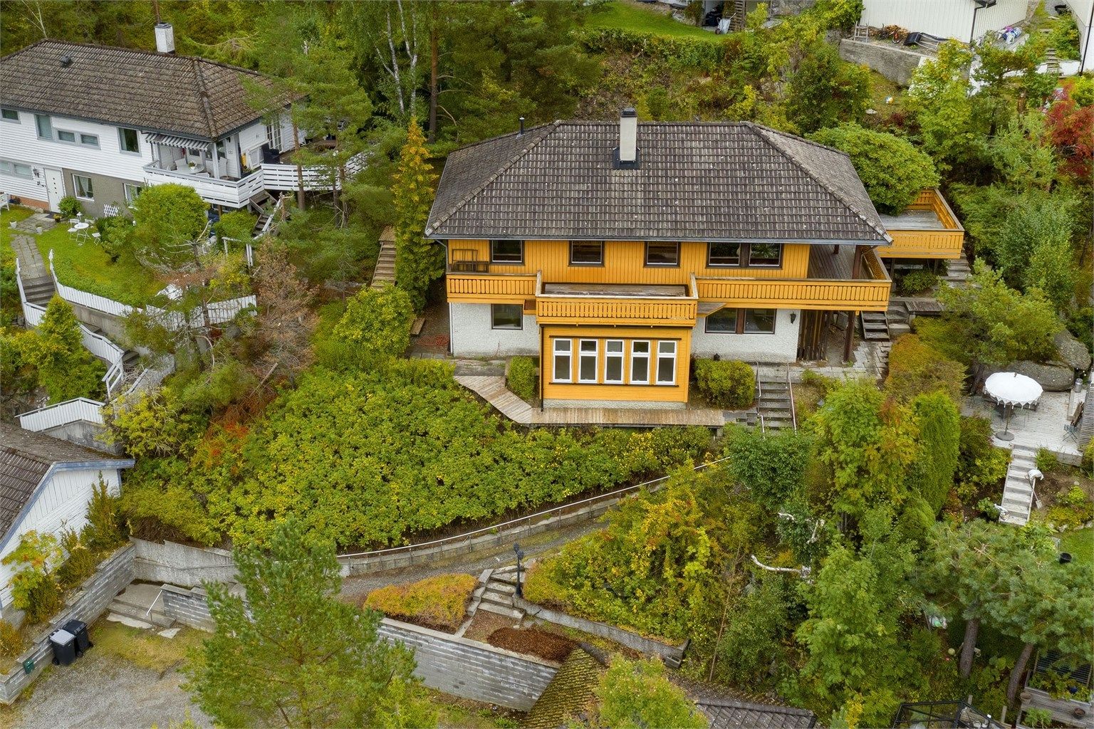 Tomten er opparbeidet med singlet gårdsplass - diverse trær og beplantninger