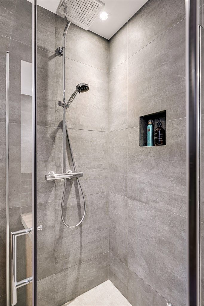 Dusjhjørnet har innfellbare glassdører og en praktisk nisje for oppbevaring.