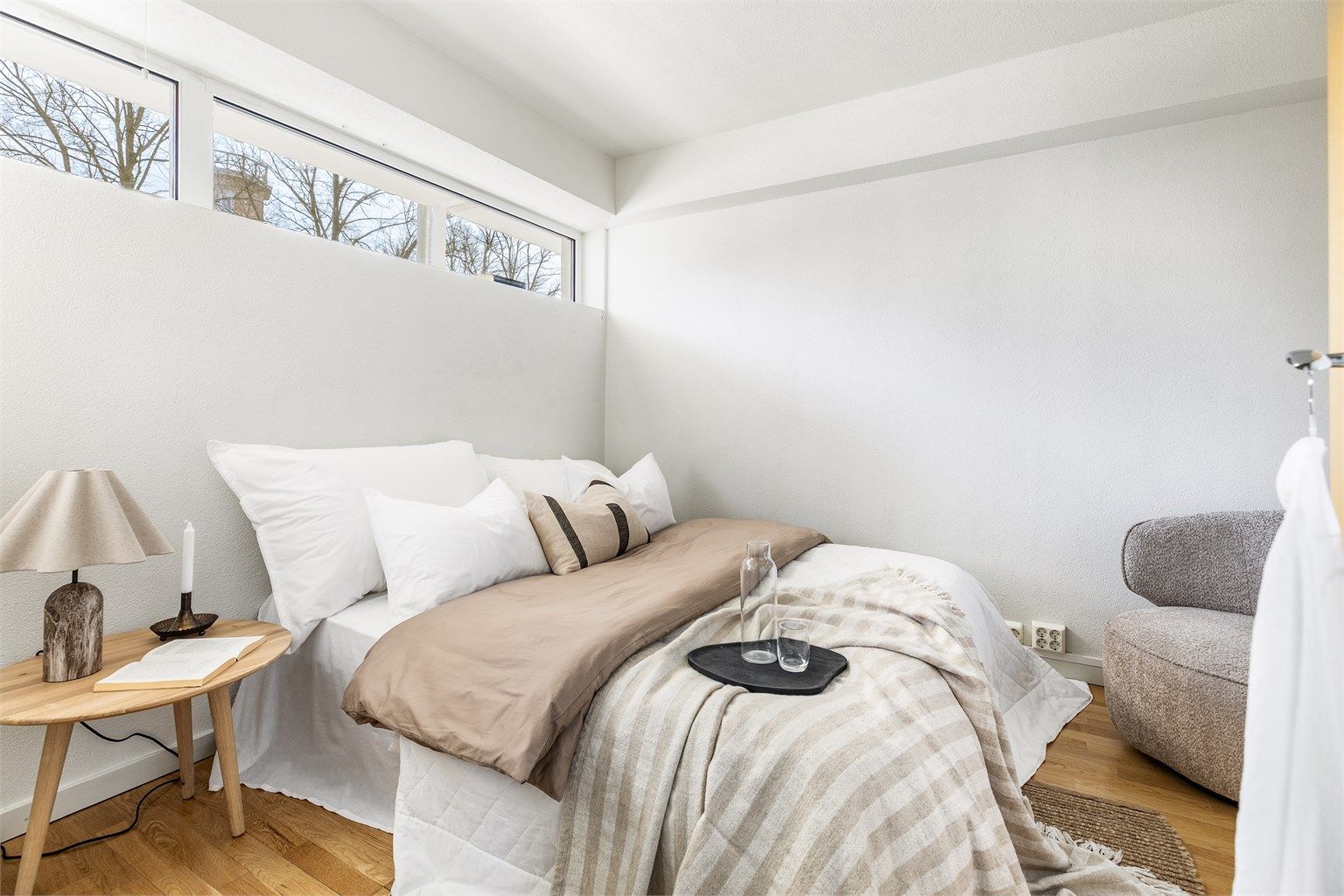 Vinduer høyt på veggen begrenser innsyn og gir samtidig overlys til hovedsoverommet.