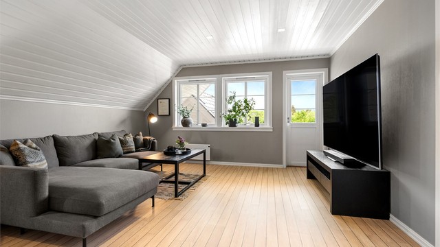 Loftstuen er et lyst og luftig rom med god plass til en stor sofagruppe.
