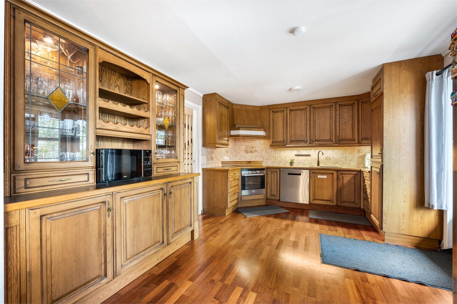 Kjøkkeninnredning med profilerte fronter fra ukjent årstall, benkeplate med laminert flate og nedfelt oppvaskkum i kompositt med ett-greps armatur.