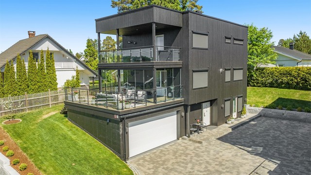 Enebolig fra 2021 med integrert dobbelgarasje, balansert ventilasjon og flere store uteplasser. Legg merke til solskjermingen.