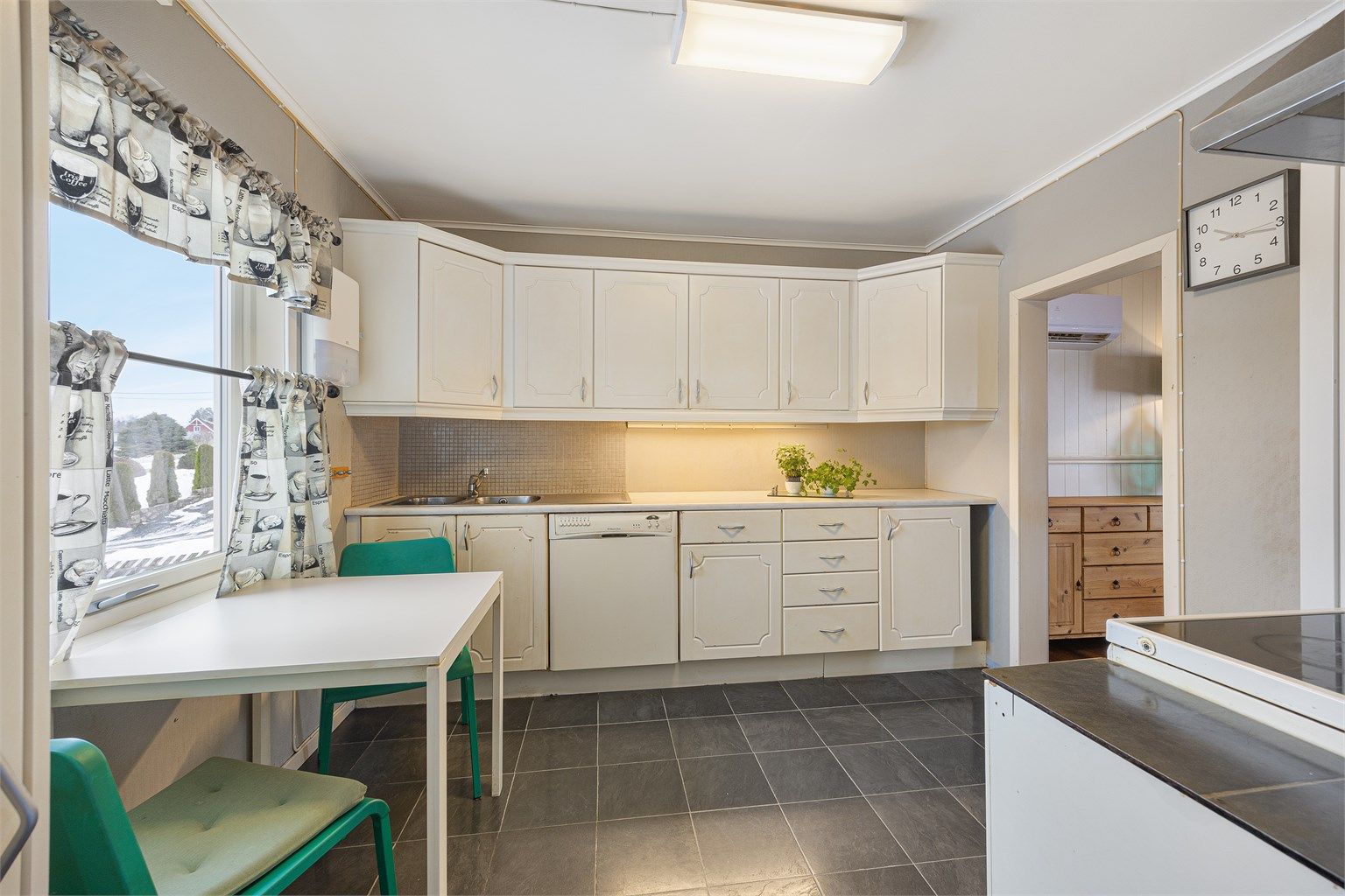 Kjøkkenet har en innredning med profilerte fronter og plass til en liten spiseplass.