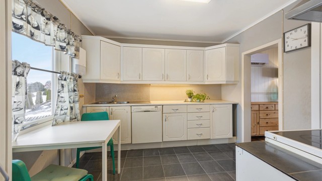 Kjøkkenet har en innredning med profilerte fronter og plass til en liten spiseplass.