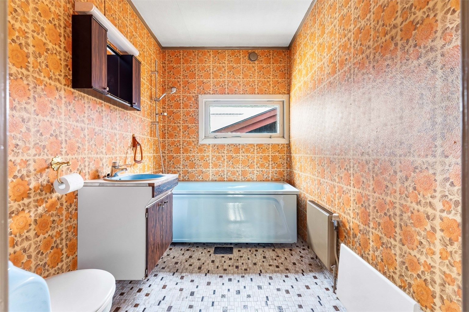 Badet er fra byggeåret og er innredet med badekar, servant og toalett.