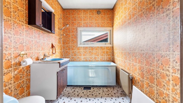 Badet er fra byggeåret og er innredet med badekar, servant og toalett.