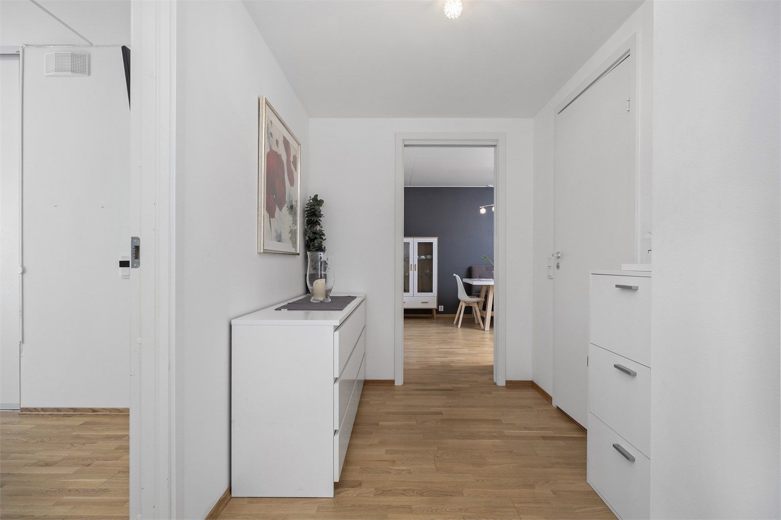 Hvitmalt og romslig entré/gang innredet med god plass til oppbevaringsmøbel etter eget ønske