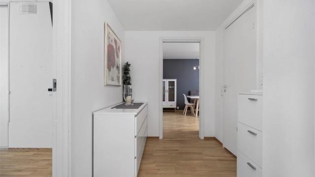 Hvitmalt og romslig entré/gang innredet med god plass til oppbevaringsmøbel etter eget ønske