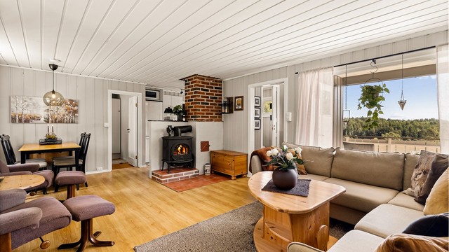 Store vindusflater sørger for rikelig med lys. Stuen har god plass til både sofagruppe, spisebord og lenestoler.