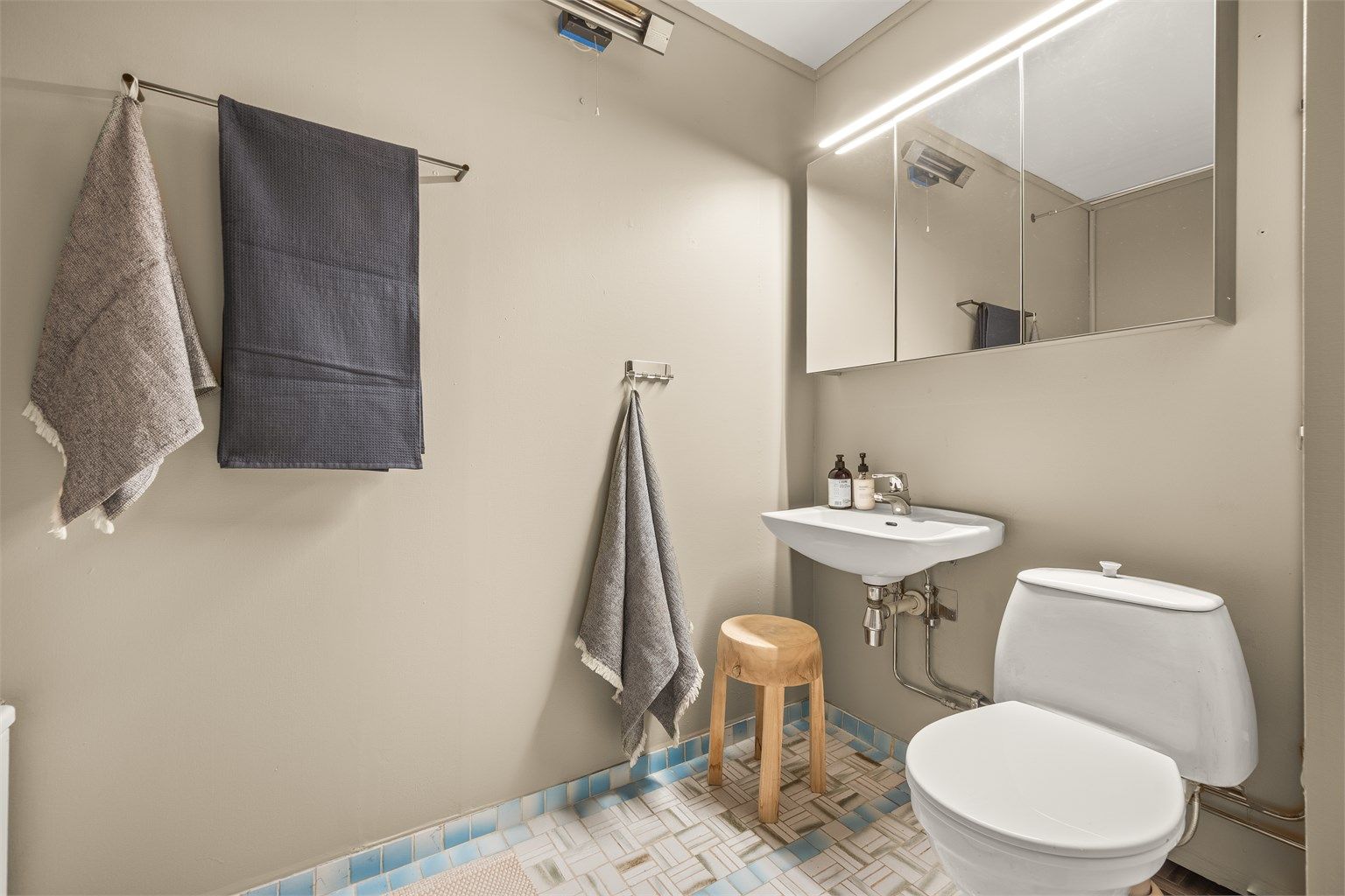 Det ene av leilighetens to bad. Badet er fra byggeår, og modernisering må påregnes.