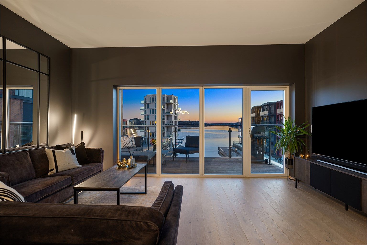 Store vindusflater i front som gir en sømløs forbindelse mellom ute- og inneområdet. Glassrekkverk på balkong sørger for skjerming uten å hindre den vakre utsikten