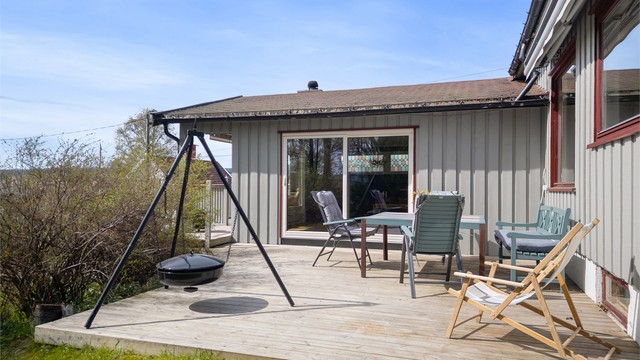 Adkomst til terrasseplatting via skyvedører fra peisestuen. Usjenert og lun uteplass med markise.