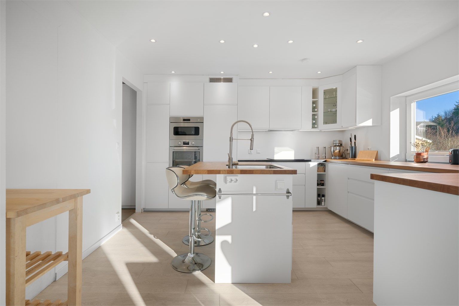 - Stilrent og moderne kjøkken med nedfelt oppvaskkum på øy, integrerte hvitevarer og rikelig med oppbevaringsplass. -