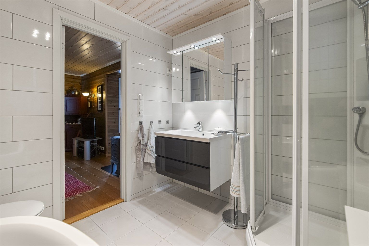 Badet ligger i soveromsavdelingen og det er innredet med varmekabler i flislagte gulv