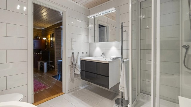 Badet ligger i soveromsavdelingen og det er innredet med varmekabler i flislagte gulv