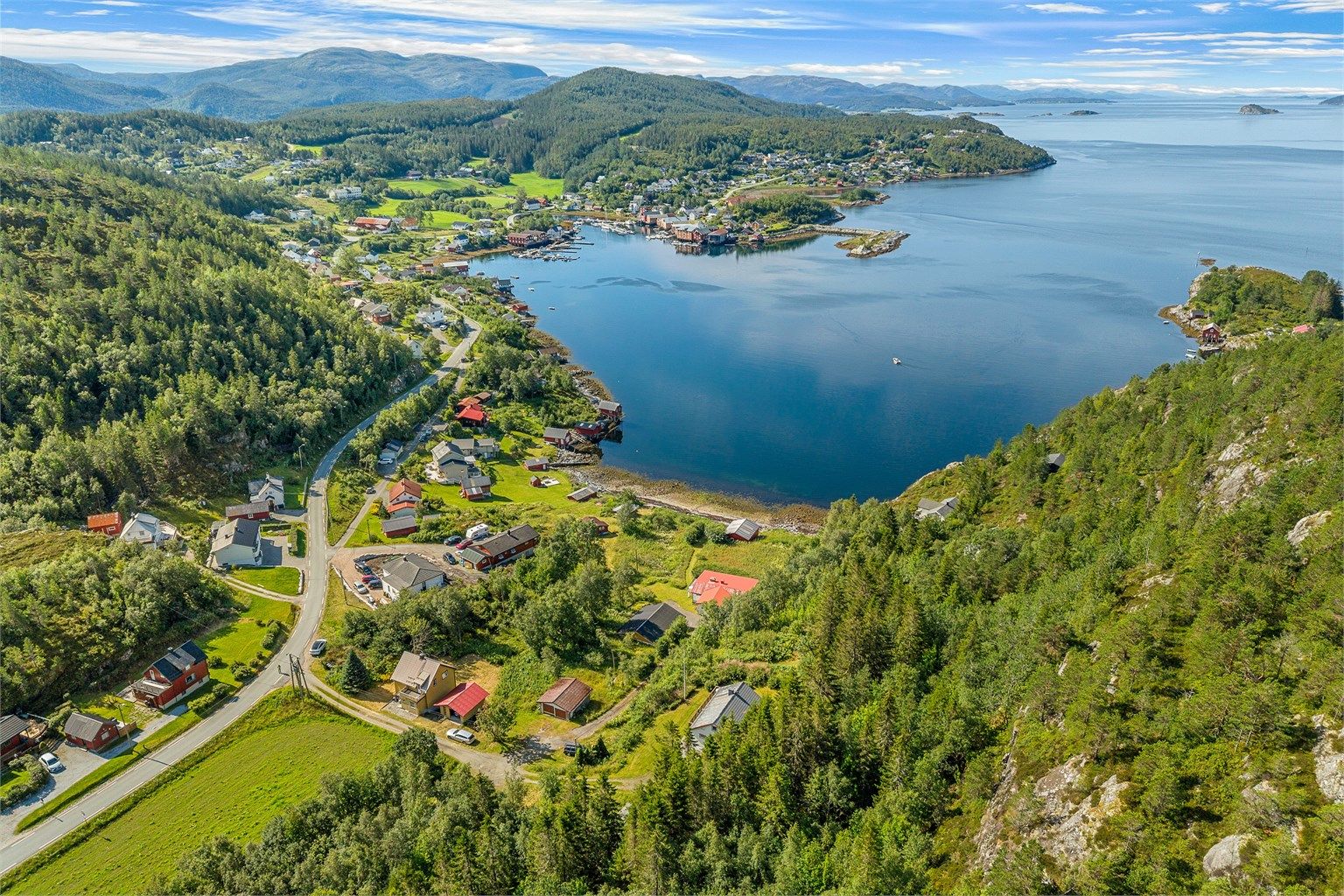 Oversiktsbilde av området som fremhever den idylliske beliggenheten ved Stjørnfjorden og nærheten til Råkvåg sentrum.